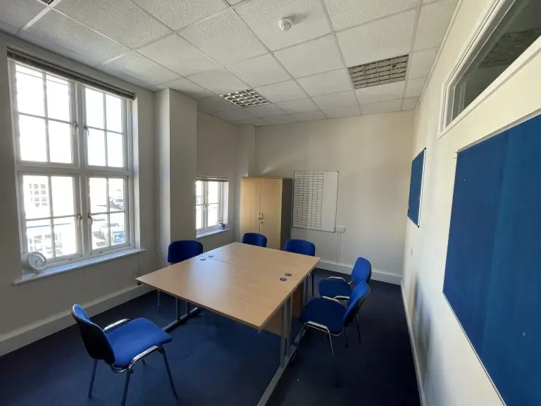 Shows small meeting room with three tables and six chairs
